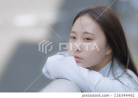 A high school girl standing in the street with a bag 116344492