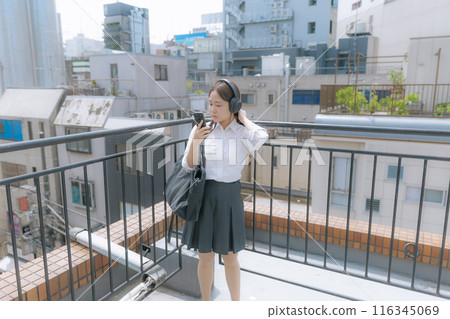 High school girl listening to music on the roof 116345069