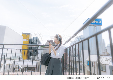 High school girl listening to music on the roof 116345072