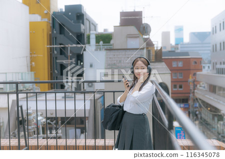 High school girl listening to music on the roof 116345078