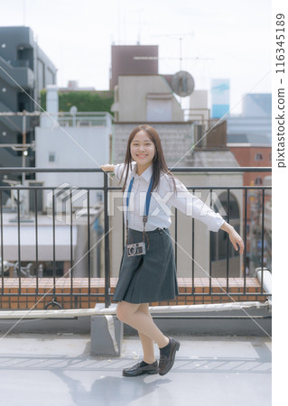 High school girl using a film camera 116345189