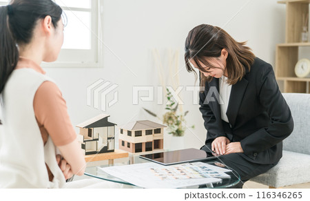 A real estate/house manufacturer businesswoman apologizing for handling a complaint A real estate/house manufacturer businesswoman apologizing for handling a complaint 116346265