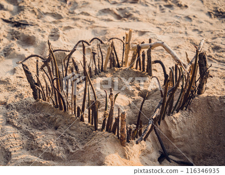 A wooden fence stands in the center of a dusty field A wooden fence stands in the center of a dusty field 116346935