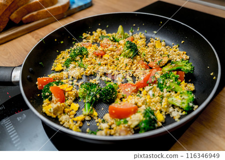 Chef at the kitchen preparing tofu scramble with vegetables 116346949