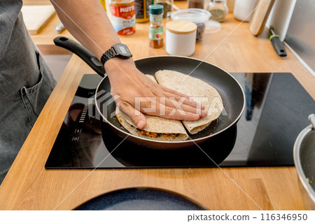 Chef at the kitchen preparing quesadillas with tofu and sweet corn 116346950