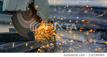Worker cutting steel rectangular pipe in construction site. Worker cutting steel rectangular pipe in construction site. 116346969