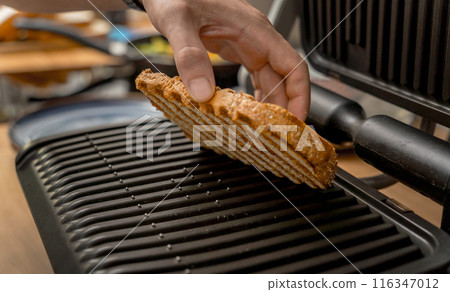Chef cooking white bread toasted on an electric grill Chef cooking white bread toasted on an electric grill 116347012