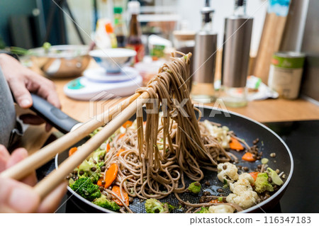 Chef at the kitchen preparing japanese buckwheat pasta with lentils 116347183