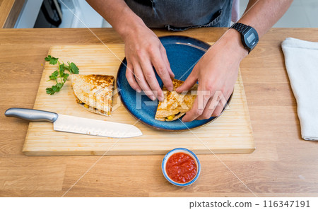 Chef at the kitchen preparing quesadillas with tofu and sweet corn 116347191
