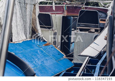 Old and rusty motor boats on a landfill surrounded by tropical forest Old and rusty motor boats on a landfill surrounded by tropical forest 116347193