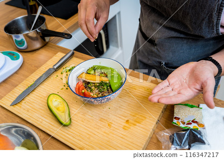 Chef at the kitchen preparing healthy quinoa bowl with avocado Chef at the kitchen preparing healthy quinoa bowl with avocado 116347217