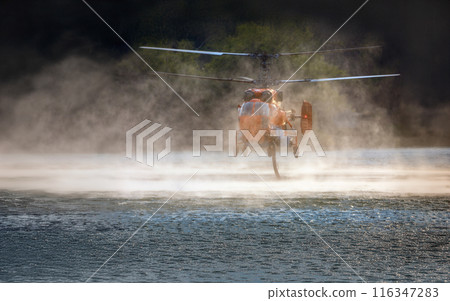 Firefighting helicopter filling up with water from lake Firefighting helicopter filling up with water from lake 116347283