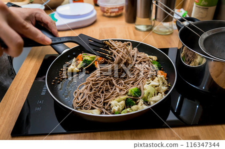 Chef at the kitchen preparing japanese buckwheat pasta with lentils 116347344