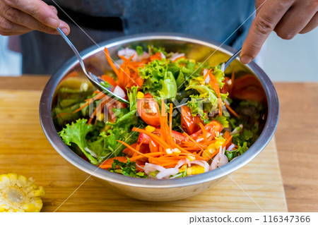 Chef at the kitchen preparing spicy glass noodle salad Chef at the kitchen preparing spicy glass noodle salad 116347366