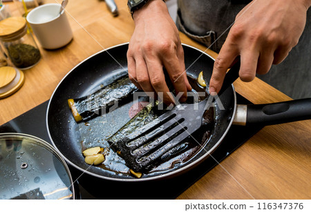 Chef at the kitchen preparing grilled eggplants with garlic Chef at the kitchen preparing grilled eggplants with garlic 116347376