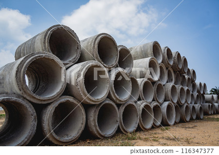 A stack of concrete ring pipes piled and creating a symmetrical arrangement A stack of concrete ring pipes piled and creating a symmetrical arrangement 116347377