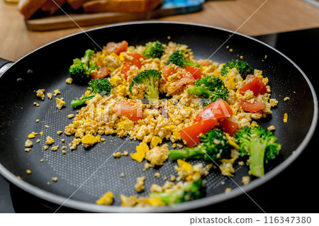 Chef at the kitchen preparing tofu scramble with vegetables 116347380