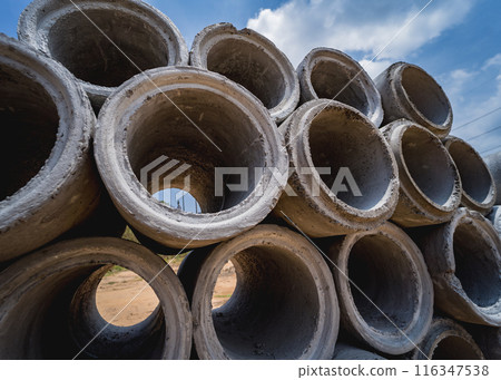 A stack of concrete ring pipes piled and creating a symmetrical arrangement 116347538