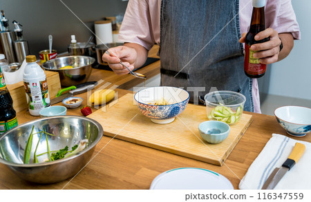 Chef at the kitchen preparing rice porridge with onion and sesame seeds 116347559