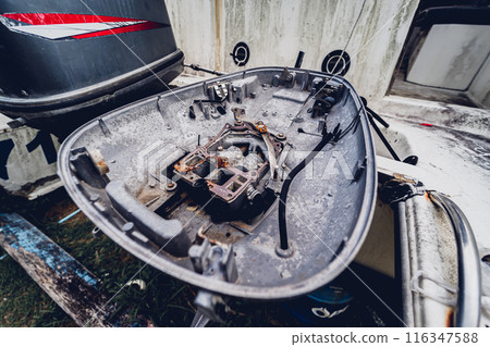 Old and rusty motor boats on a landfill surrounded by tropical forest 116347588