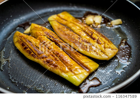 Delicious grilled eggplants with garlic on the fried pan 116347589