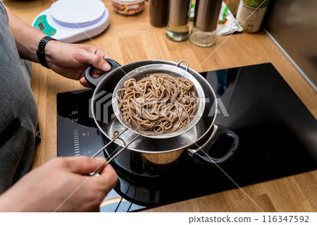 Chef at the kitchen preparing japanese buckwheat pasta with lentils Chef at the kitchen preparing japanese buckwheat pasta with lentils 116347592