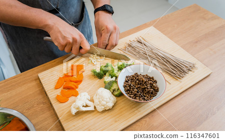 Chef at the kitchen preparing japanese buckwheat pasta with lentils Chef at the kitchen preparing japanese buckwheat pasta with lentils 116347601