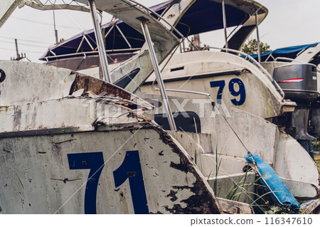 Old and rusty motor boats on a landfill surrounded by tropical forest 116347610