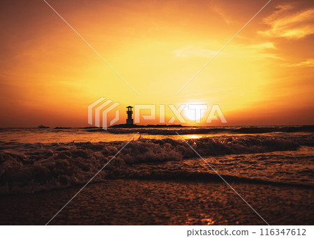 A lighthouse in the ocean during a beautiful sunset 116347612