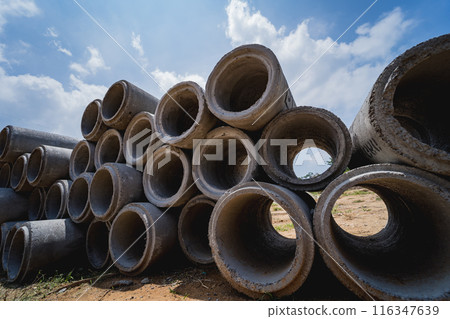 A stack of concrete ring pipes piled and creating a symmetrical arrangement 116347639