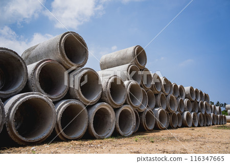A stack of concrete ring pipes piled and creating a symmetrical arrangement 116347665