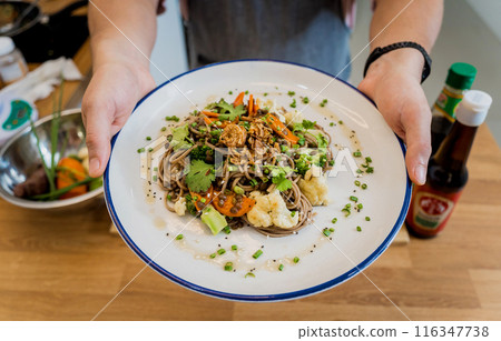 Chef at the kitchen preparing japanese buckwheat pasta with lentils 116347738