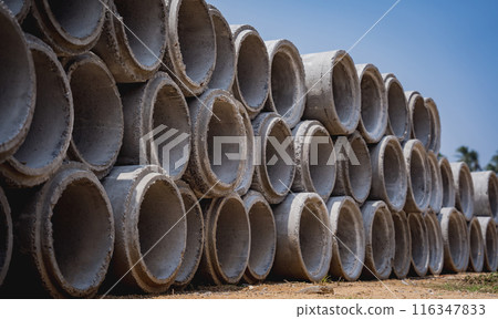 A stack of concrete ring pipes piled and creating a symmetrical arrangement A stack of concrete ring pipes piled and creating a symmetrical arrangement 116347833