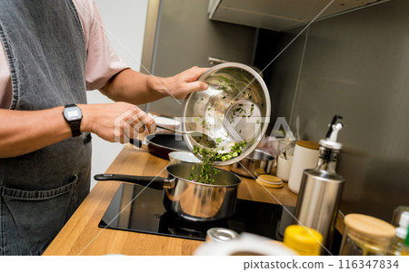 Chef at the kitchen preparing green curry with herbs and rice Chef at the kitchen preparing green curry with herbs and rice 116347834