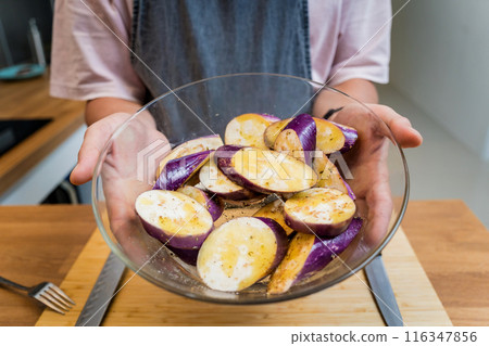 Chef at the kitchen preparing grilled eggplants with garlic 116347856