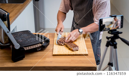 The chef is broadcasting live from workshop how to prepare a beef steaks on the electric grill The chef is broadcasting live from workshop how to prepare a beef steaks on the electric grill 116347859