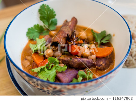 A vegetarian massaman curry in a bowl with sweet potato and many spices 116347908