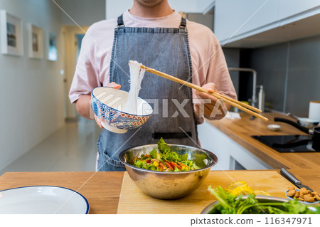 Chef at the kitchen preparing spicy glass noodle salad Chef at the kitchen preparing spicy glass noodle salad 116347971