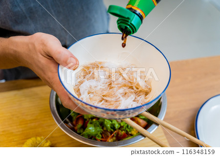 Chef at the kitchen preparing spicy glass noodle salad Chef at the kitchen preparing spicy glass noodle salad 116348159
