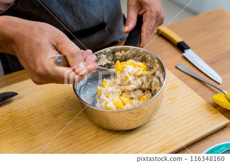 Chef at the kitchen preparing bowl of oats with strawberries and mango Chef at the kitchen preparing bowl of oats with strawberries and mango 116348160
