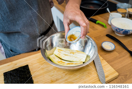 Chef at the kitchen preparing grilled eggplants with garlic Chef at the kitchen preparing grilled eggplants with garlic 116348161