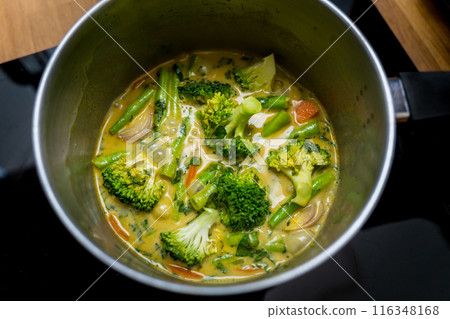 Chef at the kitchen preparing green curry with herbs and rice Chef at the kitchen preparing green curry with herbs and rice 116348168