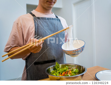 Chef at the kitchen preparing spicy glass noodle salad Chef at the kitchen preparing spicy glass noodle salad 116348224