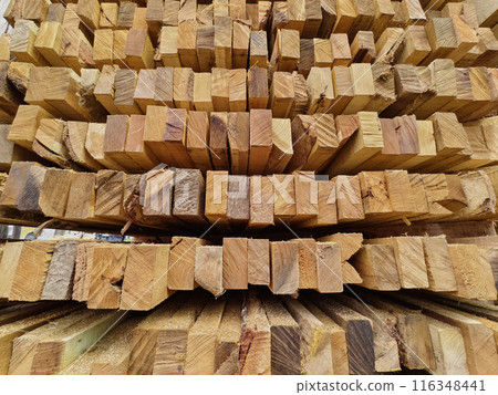 A pile of wood is arranged in a stack on top of one another 116348441