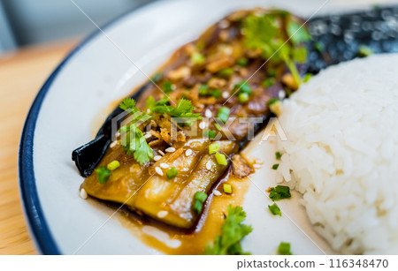 Delicious grilled eggplants with garlic on the white plate Delicious grilled eggplants with garlic on the white plate 116348470