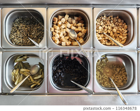 Buffet table stocked with an array of salads and veggies Buffet table stocked with an array of salads and veggies 116348678