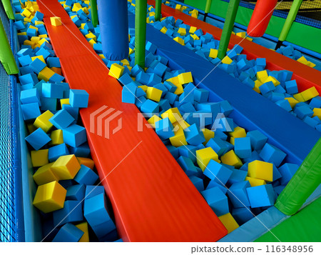 Trampoline park has blue and yellow foam cubes for kids fun 116348956