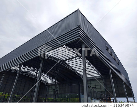 A large building with metal roof against a cloudy sky A large building with metal roof against a cloudy sky 116349074