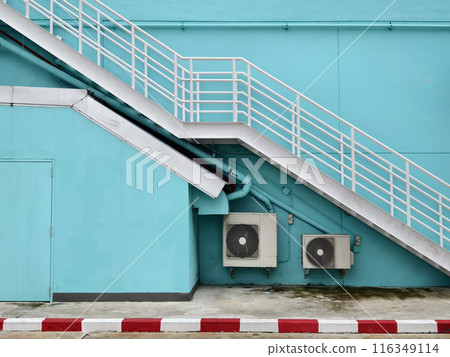Metal stairs to blue building against sky and clouds Metal stairs to blue building against sky and clouds 116349114