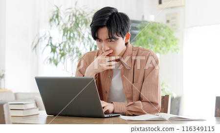 A man thinking at a computer A man thinking at a computer 116349115